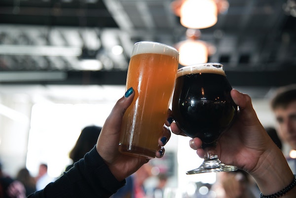 Two people doing a cheers with beer glasses